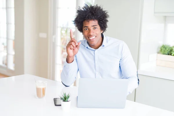노트북을 사용하여 일하는 아프리카 미국인 사업가가 행복한 얼굴로 손가락을 가리키는 — 스톡 사진