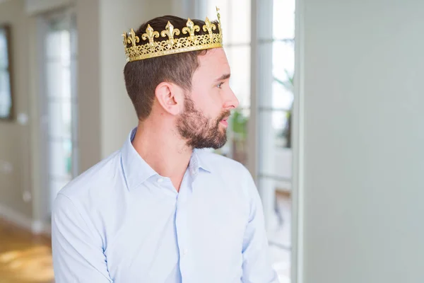 英俊的商人穿着金冠作为国王或王子寻找一边 放松配置文件姿势与自然的脸与自信的微笑 — 图库照片