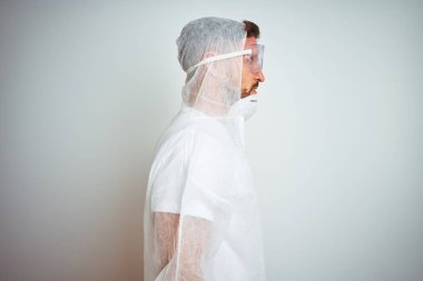 Yan bakarak izole arka plan üzerinde profesyonel işçi ekipmanları koruma giyen ressam adam, kendine güvenen gülümseme ile doğal yüz ile profil poz dinlenmek.