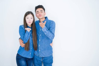 Beyaz izole arka plan üzerinde güzel genç asyalı çift güzel ve seksi olmak hava el iyle bir öpücük üfleme kameraya bakarak. Aşk ifadesi.