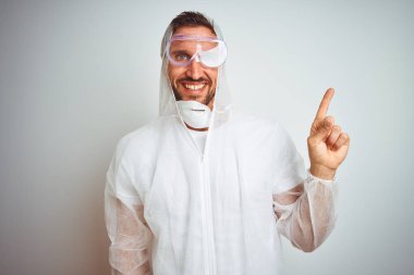 Yüzünde büyük bir gülümseme ile izole arka plan üzerinde profesyonel işçi ekipman koruma giyen ressam adam, kameraya bakarak yan el ve parmak ile işaret.