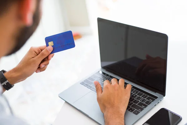 Uomo che utilizza la carta di credito come metodo di pagamento quando lo shopping online usin — Foto Stock