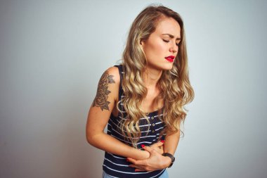 Genç güzel kadın çizgili t-shirt mide üzerinde el ile beyaz izole arka plan üzerinde duran giyen çünkü hazımsızlık, ağrılı hastalık duygusu. Ağrı kavramı.