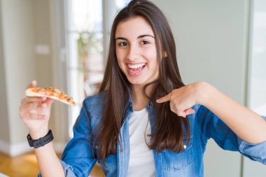 Güzel genç kadın kendini işaret sürpriz yüzü ile lezzetli pizza bir dilim yemek