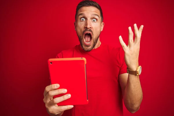 Hombre Joven Usando Tableta Táctil Digital Sobre Fondo Rojo Aislado —  Fotos de Stock