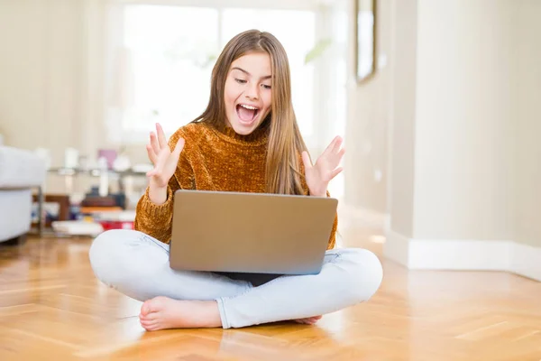 美丽的年轻女孩学习使用笔记本电脑坐在地板上在家里很高兴和兴奋 胜利者的表情庆祝胜利尖叫与大大的微笑和举手 — 图库照片