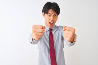 Izole beyaz arka plan üzerinde duran zarif kravat giyen Çinli işadamı kızgın ve öfkeli öfke ile bağırırken sinirli ve öfkeli yumruklar yükselterek. Öfke ve agresif kavram.