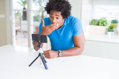 Afro-Amerikan adam hata için utanç ile şok el ile akıllı telefon kapağı ağız kullanarak web kamerası ile online arama yapıyor, korku ifadesi, sessizlik, gizli kavram korkmuş