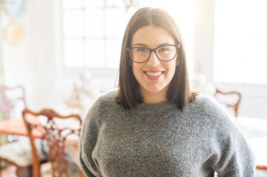 Gözlük giyen genç güzel kadın neşeli ayakta gülümseyen 