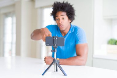 Afro-Amerikan adam kamera ve size parmak ile işaret akıllı telefon kullanarak web kamerası ile online arama yapıyor, el işareti, önden olumlu ve kendinden emin jest