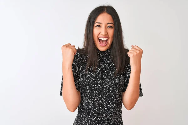 İzole beyaz arka plan üzerinde duran zarif t-shirt giyen genç Çinli kadın kollarını kaldırdı ve gözleri açık başarı için şaşırttı. Kazanan kavramı.
