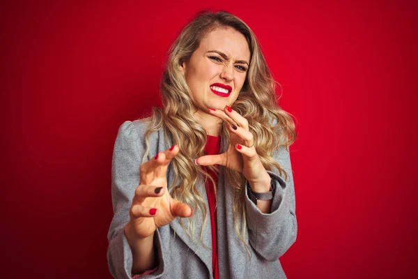 Young beautiful business woman wearing elegant jacket standing over red isolated background disgusted expression, displeased and fearful doing disgust face because aversion reaction. With hands raised. Annoying concept.