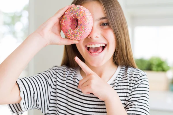 Hermosa Niña Comiendo Donut Rosa Dulce Muy Feliz Señalando Con —  Fotos de Stock