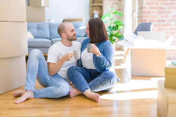 Junges Paar sitzt auf dem Boden des neuen Hauses aus Karton — Stockfoto