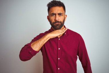 İzole gri arka plan üzerinde duran kırmızı zarif gömlek giyen genç hintli adam bıçak gibi el ile boğaz kesme, öfkeli şiddet ile saldırganlık tehdit