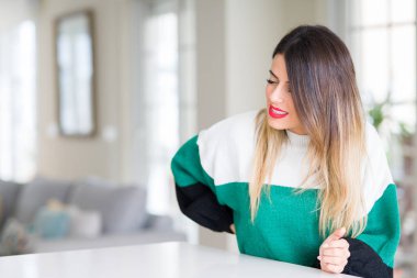 Sırt ağrısı, ev acı dokunmadan el ile geri, kas ağrısı, kış kazak giyen genç güzel kadın