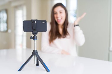 Akıllı telefon web kamerası ile selfie video kayıt güzel genç kadın çok mutlu ve heyecanlı, kazanan ifade büyük bir gülümseme ile çığlık zafer kutluyor ve ellerini kaldırdı