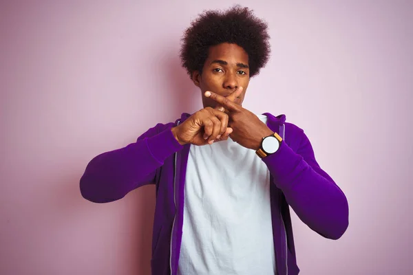 年轻的非洲裔美国男子穿着紫色运动衫站在孤立的粉红色背景拒绝表达交叉手指做负面符号 — 图库照片