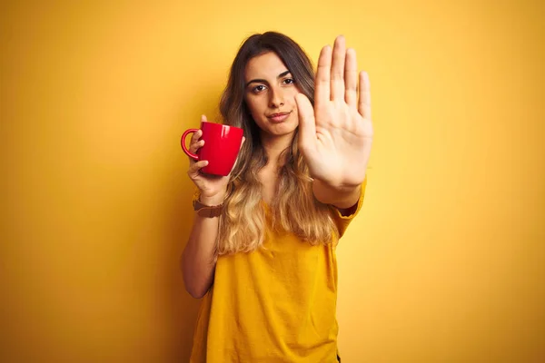 Νέα Όμορφη Γυναίκα Κρατώντας Κόκκινο Φλιτζάνι Καφέ Πάνω Από Κίτρινο — Φωτογραφία Αρχείου