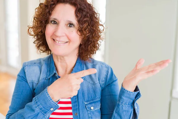 Güzel yaşlı kadın şaşırttı ve el ile sunarken kameraya gülümseyerek ve parmak ile işaret.