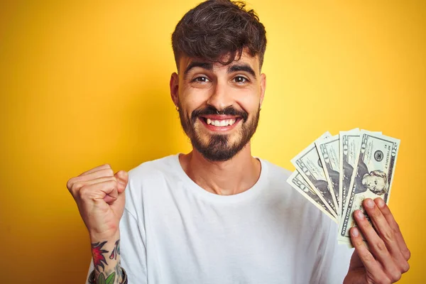 Ung Man Med Tatuering Innehav Dollar Stående Över Isolerad Gul — Stockfoto