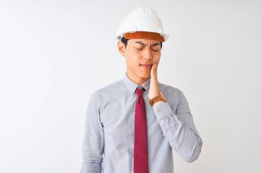 Çinli mimar adam kravat ve kask giyen izole beyaz arka plan üzerinde diş ağrısı veya diş üzerinde diş hastalığı nedeniyle ağrılı ifade ile el ile ağız dokunmadan ayakta. Diş hekimi konsepti.