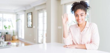 Afro saçlı güzel afro-amerikan kadın geniş açı merhaba mutlu ve gülümseyen, samimi hoş geldin jestsöyleyerek Waiving