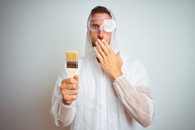 Profesyonel işçi ekipmanları takan ressam, izole arka plan kapağı ağız üzerinde fırça tutan el ile hata için utanç ile şok, korku ifadesi, sessizlik, gizli kavram korkmuş