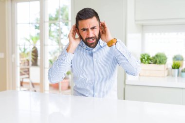 Yakışıklı İspanyol iş adamı iki elini de kulak jestiyle duymaya çalışıyor, dedikoduya meraklı. İşitme sorunu, sağır