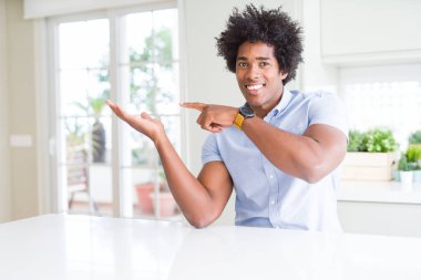 Afro-Amerikan iş adamı şaşırttı ve el ile sunarken kameraya gülümseyerek ve parmak ile işaret.