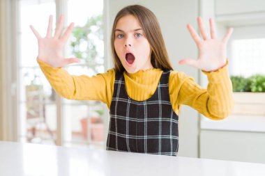 Genç güzel sarışın çocuk kız evde rahat sarı kazak giyen avuç içi, kızgın ve hayal kırıklığı ifade ile stop jest yapıyor