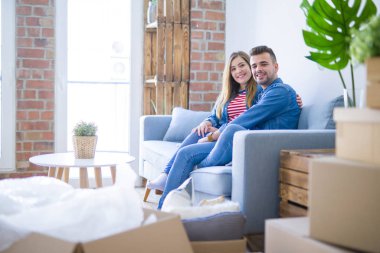 Genç güzel çift oturan ve yeni ap de kanepede sarılma