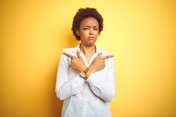 고립된 노란색 배경을 아프리카계 미국인 비즈니스 여성은 손가락으로 양쪽을 가리키는 — 스톡 사진