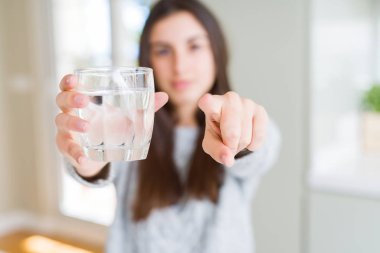 Güzel genç kadın kameraya parmakla işaret eden taze bir bardak su içme ve size, el işareti, önden olumlu ve kendinden emin jest