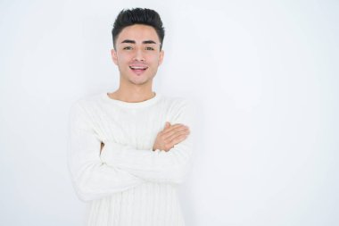 Beyaz izole arka plan üzerinde Yakışıklı genç adam kamera bakarak çapraz kolları ile gülümseyen mutlu yüz. Pozitif kişi.