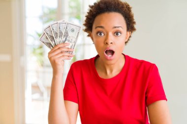 Genç Afrikalı Amerikalı kadın 50 dolar banka notları tutan şok sürpriz bir yüz ile korkuyor ve korku ifadesi ile heyecanlı korkmuş