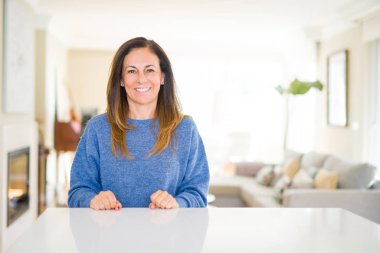 Güzel orta yaş kadın evde yüzünde mutlu ve serin bir gülümseme ile. Şanslı kişi.