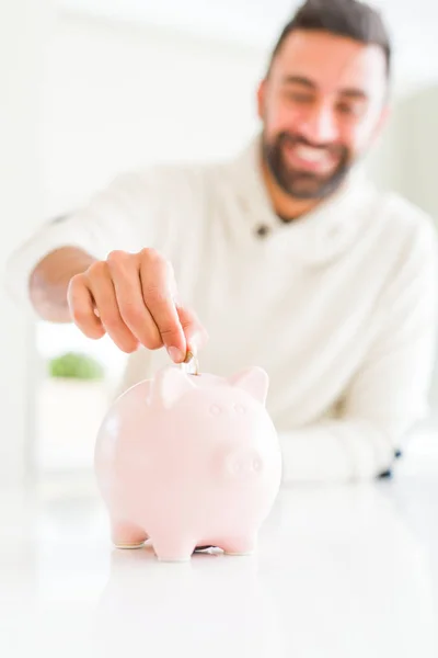 Człowiek uśmiechnięty oddanie monety wewnątrz Skarbonka oszczędności dla wves — Zdjęcie stockowe