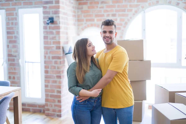 Молодая красивая пара влюблена в картонные коробки, переезжающие в — стоковое фото