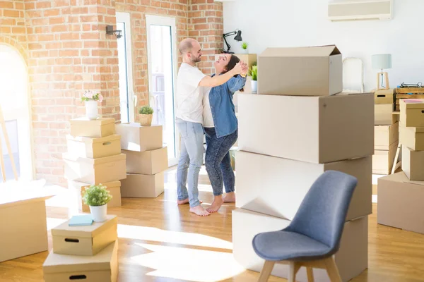 Pareja joven bailando alrededor de cajas de cartón en casa nueva, celebran — Foto de Stock