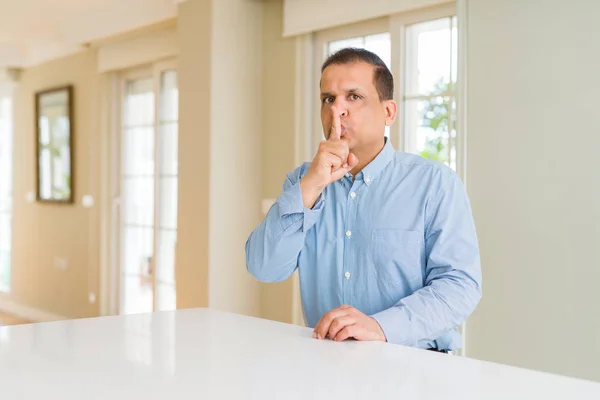 Orta Yaşlı Adam Evde Oturmuş Dudaklarında Parmakla Sessiz Olmak Istiyor — Stok fotoğraf