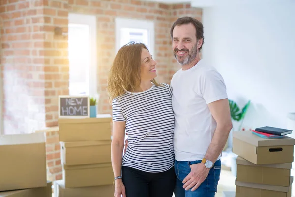 Middle age senior couple moving to a new house, smiling happy in