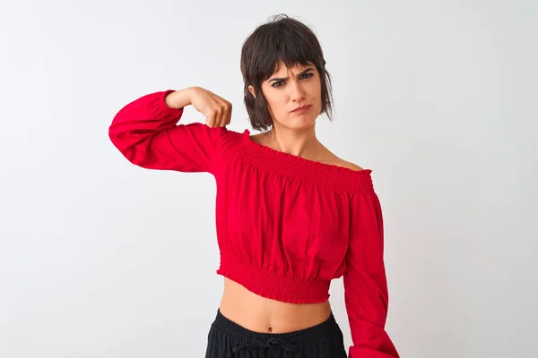 年轻的美女穿着红色夏季T恤站在孤立的白色背景强人显示手臂肌肉 自信和自豪的力量 — 图库照片
