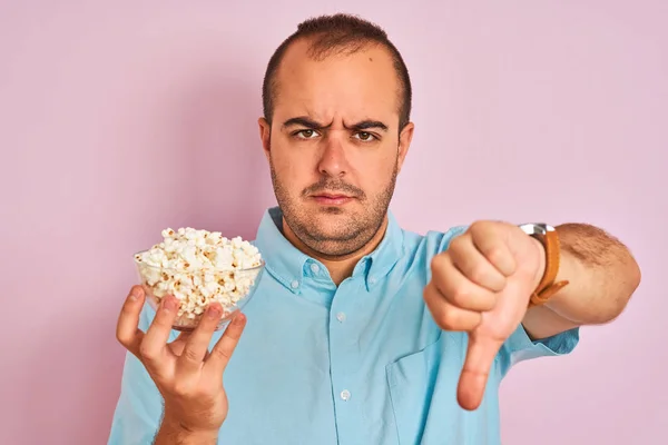 Giovane Uomo Possesso Ciotola Con Popcorn Piedi Sfondo Rosa Isolato — Foto Stock