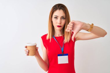Kırmızı kafalı iş kadını kızgın yüz ile izole beyaz arka plan üzerinde kahve içme kimlik kartı içme fincan giyen, başparmak aşağı, ret kavramı ile sevmediğimi gösteren negatif işareti