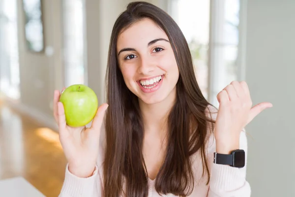 Schöne Junge Frau Isst Gesunde Grüne Apfelfrüchte Und Zeigt Mit — Stockfoto