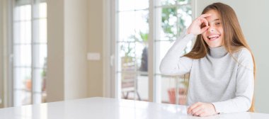 Rahat kazak giyen güzel genç kız çocuğun geniş açılı resmi el gülümseyerek ok jest yapıyor, mutlu yüzlü parmaklardan bakan göz.