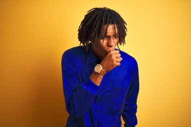 Izole sarı arka plan üzerinde mekanik üniforma giyen dreadlocks ile Afro işçi adam rahatsız duygu ve soğuk veya bronşit için belirti olarak öksürük. Sağlık kavramı.