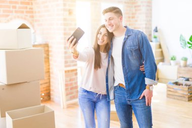 Güzel genç çift akıllı telefon ile bir selfie fotoğrafı alarak mutlu gülümseyen, çok yeni bir eve hareket heyecanlı