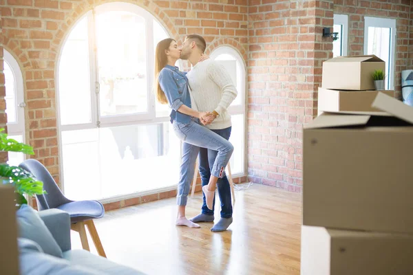 Beautiful young couple moving to a new home, dancing in love celebrating new apartment